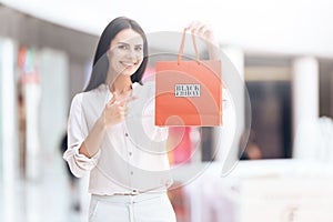 Beautiful woman with shopping bags in mall. Black Friday.