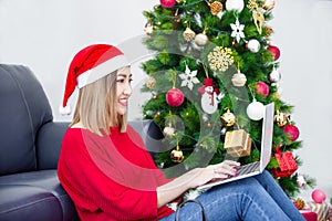 Beautiful woman shopping online via notebook computer on Christmas day