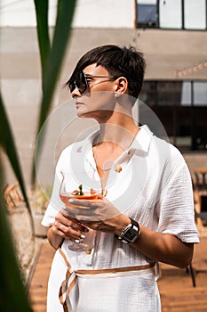 Beautiful woman with short brunette hair in white clothes and sunglasses. Fashion street photography. Fashion model