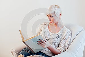 Beautiful woman with short hair reading a book