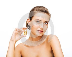 Beautiful woman showing bottle with golden dust