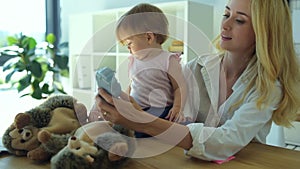 Beautiful woman showing different toys to the child