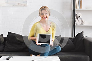 beautiful woman showing digital tablet with blank screen and smiling