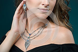 Beautiful woman showing off her jewelery in fashion concept wearing accessories and jewelry isolated over dark background photo