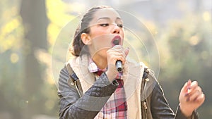 Beautiful woman singing with the microphone