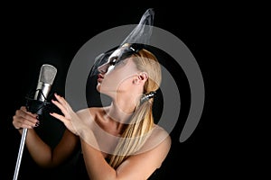 Beautiful woman singing on a vintage microphone