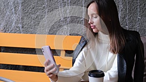 A beautiful woman sits in a cafe and takes a selfie. Casual lifestyle portrait. Businesswoman