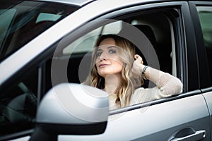 Beautiful woman sitting in car on a driver`s seat