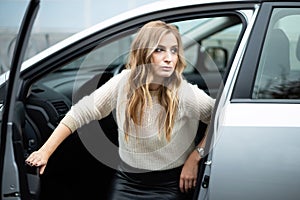 Beautiful woman sitting in car on a driver`s seat