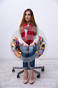 Beautiful woman sitting on the colourful chair