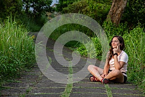 Beautiful woman sitting on famous tiles path surrounded by nature in Bali & x28;Indonesia