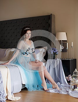 Beautiful woman sitting on a luxurious bed