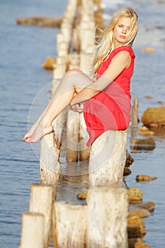 Beautiful woman sitting on old wooden bridge