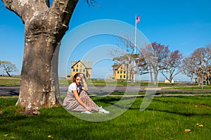 Beautiful woman is sitting in the park near the tree.