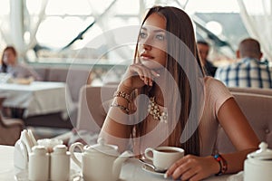 Beautiful woman sitting in a restaurant and drinking tea.