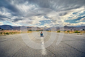 Beautiful woman sitting on the road