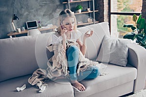 Beautiful woman sitting on sofa in her living room having tissue