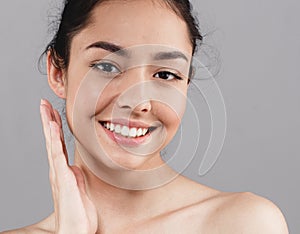 Beautiful woman skincare beauty face teeth smile with handsclo