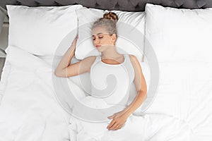 Beautiful woman sleeping on comfortable pillow in bed at home