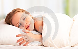 Beautiful woman sleeping and smiles in his sleep in bed