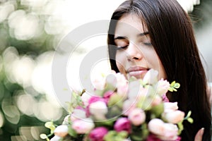 Beautiful woman smelling flowers