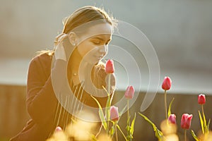 Beautiful woman smelling the tulips planted.