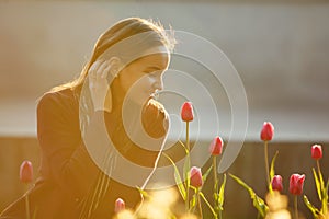 Beautiful woman smelling the tulips planted.