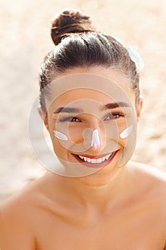 Beautiful Woman smile applying sun cream on face. Skin and  Body  care. Sun protection.