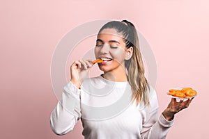 Beautiful woman with smile on her face and eyes closed enjoying eating carrot. healthy organic food concept