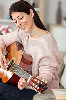 beautiful woman smile while playing acoustic guitar