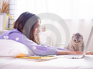 A beautiful woman smiled and played with cats on the bed in the house