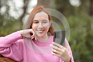 Beautiful woman smiles while making video call with her new smartphone