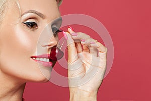 Beautiful woman smiling closeup, smile with white teeth and red cherry berry in her hand