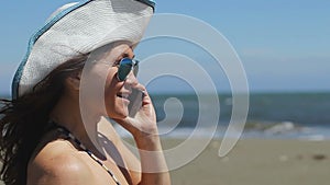 Beautiful woman smiling, dialing number, talking on phone, ending call on beach