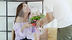 Beautiful woman smiling with flowers and gift surprise Valentine