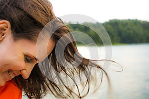 Beautiful woman smiling happy on sunny summer day outside by lake