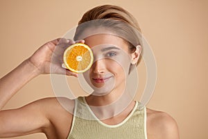 Beautiful woman smiling with orange fruit. Woman recommended vitamin for skin