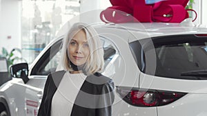 Beautiful woman smiling to the camera while choosing new automobile