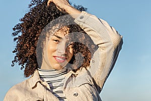 Beautiful woman smiling and touching her afro hair