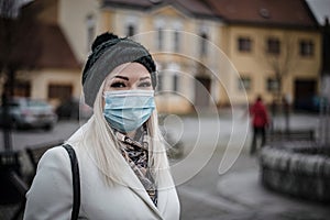 Beautiful woman smiling under her face mask she is wearing to protect others during pandemic