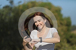 Happy woman using a smartphone and a watch photo