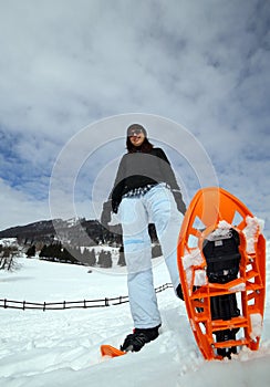 Beautiful woman with snowshoes in the snow photo