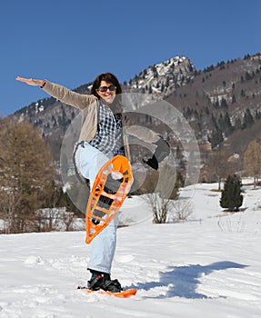 Beautiful woman with snowshoes in snowy mountain photo