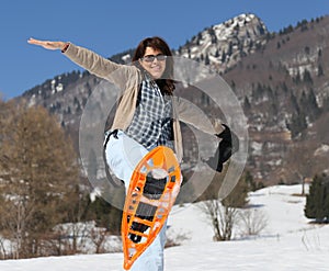 Beautiful woman with snowshoes in winter in snowy mountain photo