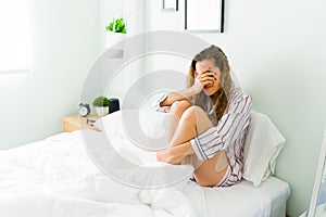 Beautiful woman sobbing and feeling sad in her bedroom