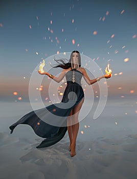 Beautiful woman sorceress holding fire in her hands. Art photo Fantasy model with flaming arms casts spell. Girl battle