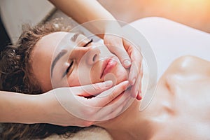 Beautiful woman in spa salon getting facial massage