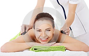 Beautiful woman on spa salon having stone massage.