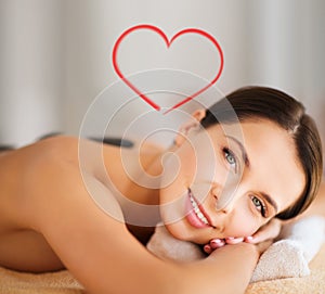 Beautiful woman in spa salon with hot stones
