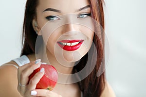 Beautiful woman with stage makeup in a white T-shirt closeup holds fresh fruits in her hands